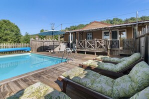 A pool area with lounge chairs and a wooden deck.