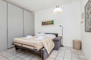 A bedroom with a bed, bedside table, lamp, and a framed picture on the wall. - [CasaSolemare] Terrace+seaview+A/C (Porto Venere)