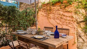An outdoor dining area with a wooden table set for two, surrounded by chairs. - [CasaSolemare] Terrace+seaview+A/C (Porto Venere)