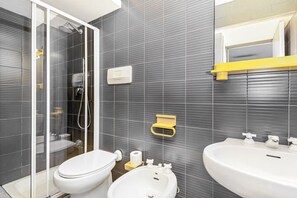 Une salle de bain moderne équipée de toilettes, d’un bidet et d’un lavabo.