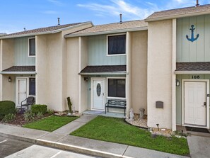 A row of townhouses with individual front doors, a bench, and a small garden area. - Escape the High-Rise | Gulf Highlands Resort for 6 (Panama City Beach)