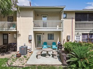 A two-story building with a balcony, outdoor seating, and a grill area. - Escape the High-Rise | Gulf Highlands Resort for 6 (Panama City Beach)