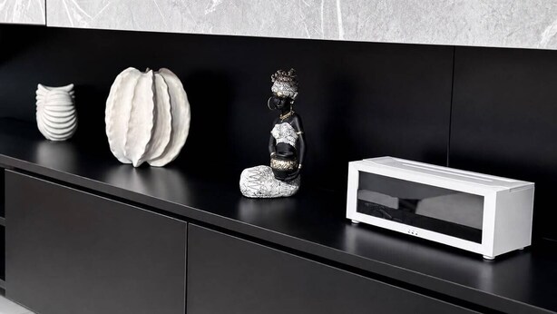 A black console table with decorative items and a white electronic device. - Uptown Homes Kampala (Kampala)