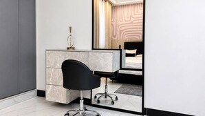 A modern bedroom with a large bed, a bedside table, and a mirror reflecting the room. - Uptown Homes Kampala (Kampala)