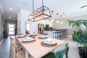 A modern kitchen with a dining area, a bar, and a living space. - ☆☆☆☆☆Price Drop! OCT-NOV - 4BR ChampionsGate - Pool - Themed Rooms! 
☆☆☆☆☆ (Davenport)