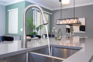 A modern kitchen with a stainless steel sink, a faucet, and a countertop. - ☆☆☆☆☆Price Drop! OCT-NOV - 4BR ChampionsGate - Pool - Themed Rooms! 
☆☆☆☆☆ (Davenport)