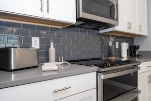 A modern kitchen with stainless steel appliances, a microwave, and a toaster. - ☆☆☆☆☆Price Drop! OCT-NOV - 4BR ChampionsGate - Pool - Themed Rooms! 
☆☆☆☆☆ (Davenport)