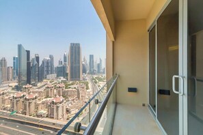 A balcony with a city view, including high-rise buildings and a highway. - Spacious Studio Fashion Ave Dubai Mall Burj view (Dubai)