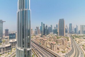 Une vue urbaine avec de hauts immeubles, une autoroute et un ciel dégagé.