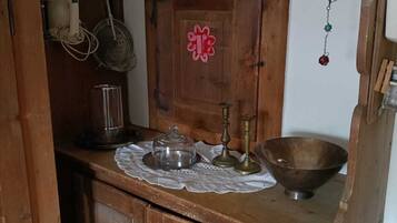 Une cuisine en bois avec un meuble en bois, un saladier en métal, un récipient en verre et un pichet en métal.