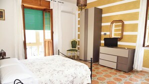 Hotellihuone, jossa on sänky, tuoli, lipasto ja televisio.