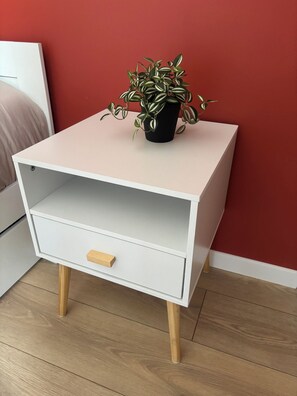 A white bedside table with a drawer and a potted plant on top. - La Parenthèse de la Baie - Charme & nature près du Mont Saint Michel (Aucey-la-Plaine)