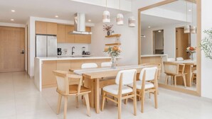 Una cucina moderna con isola centrale, sedie di legno e lampade a sospensione.