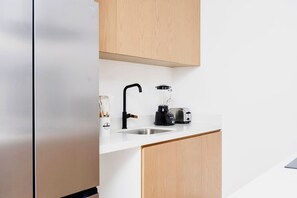A kitchen with a white countertop, a black faucet, a blender, and a toaster. - Coyote Tower 203 | Luxury Studio Walk to Marina (Cabo San Lucas)