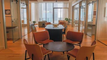 A modern conference room with a round table, six chairs, and glass walls.