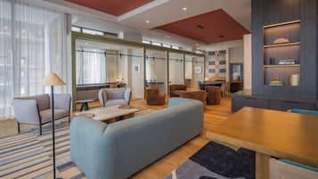 A modern interior with a sofa, chairs, a dining table, and a bookshelf.
