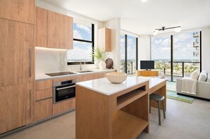 Una cocina moderna con armarios de madera, horno empotrado y un ventanal grande.