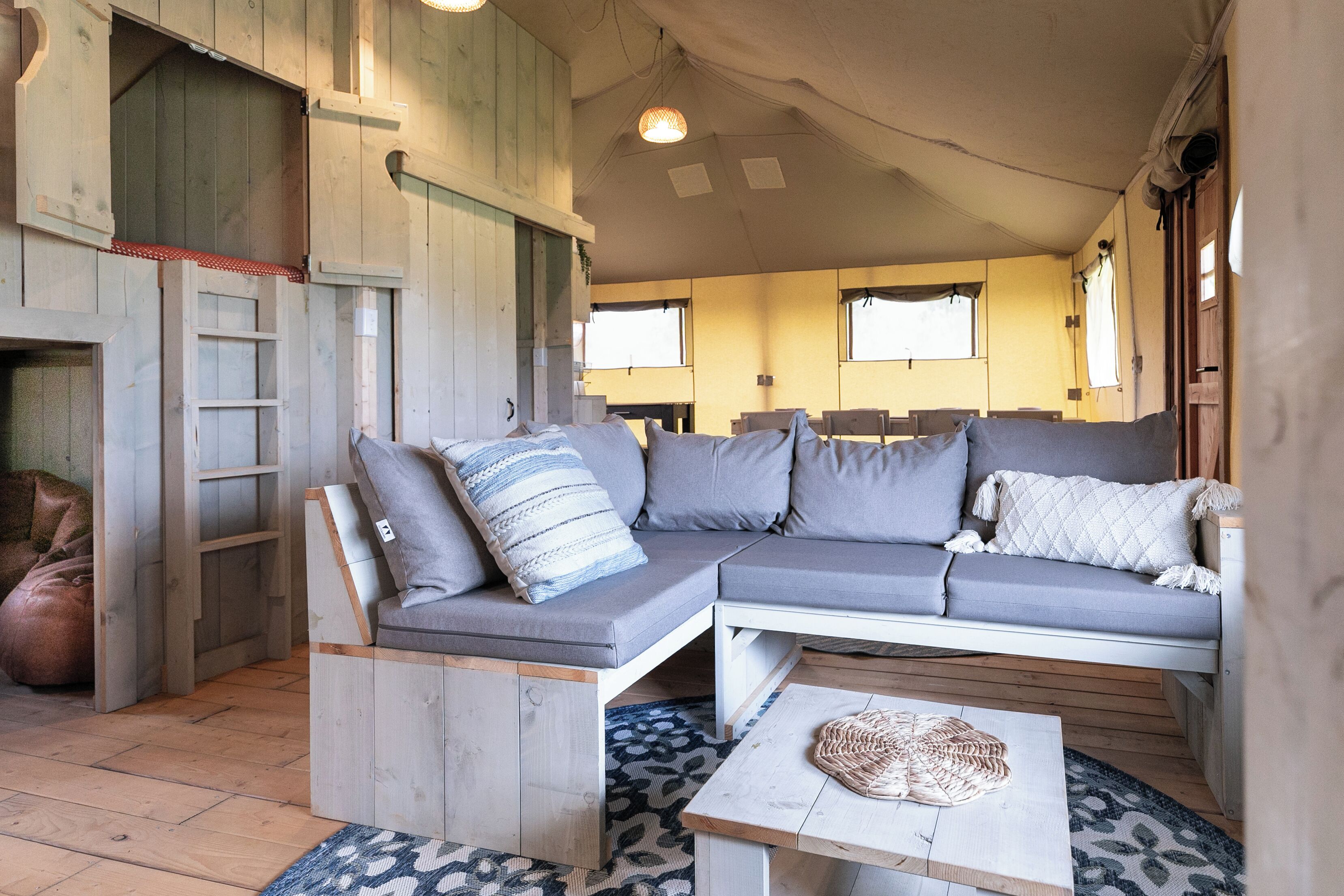 A cozy interior with a wooden sofa, a small table, and a patterned rug.