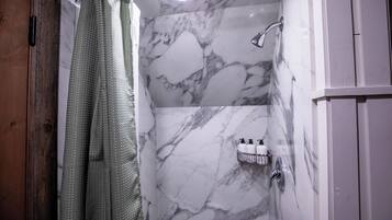 Een douche, handdoeken, zeep, shampoo