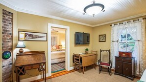A room with a bed, a desk, a television, and a window with curtains. - Vintage Saluda Escape Near Waterfalls (Saluda)