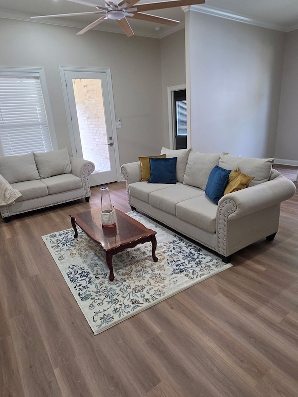 A living room with two sofas, a coffee table, and a patterned rug.
