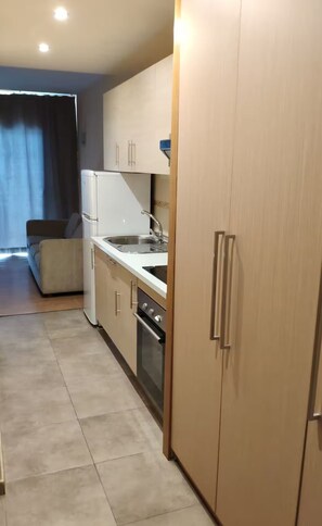 A compact kitchen with a refrigerator, stove, and sink. - Excellent apartment with splendid ocean views (Puerto de la Cruz)