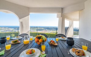 Ein Esstisch mit Frühstücksangeboten und Blick auf die Landschaft.