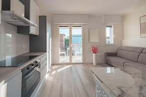 Une cuisine moderne dotée d’un four encastré et d’un coin repas avec une table et des chaises.