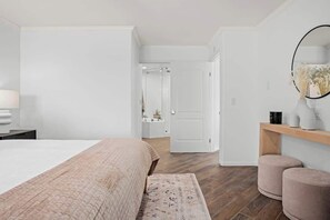 Ein Schlafzimmer mit einem Bett, einem Nachttisch und einem Spiegel an der Wand.