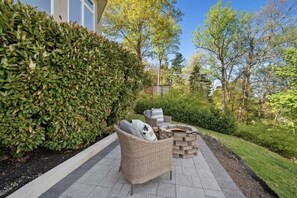 A patio area with outdoor furniture and a stone fire pit.