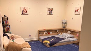 A child's bedroom with a bed, a bean bag, a bookshelf, and wall decorations. - Elevated Luxury Living with Sweeping NYC Skyline Views 6-bed house in Montclair (Montclair)