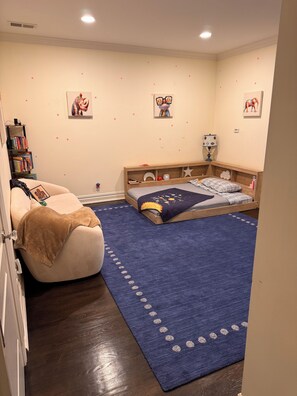 A child's bedroom with a bed, a bean bag, a bookshelf, and wall decorations. - Elevated Luxury Living with Sweeping NYC Skyline Views 6-bed house in Montclair (Montclair)