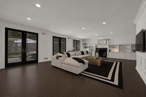 A spacious living room with a large sectional sofa, a coffee table, and a fireplace.