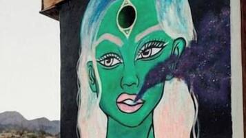A building with a mural of a woman with green hair and a black background.