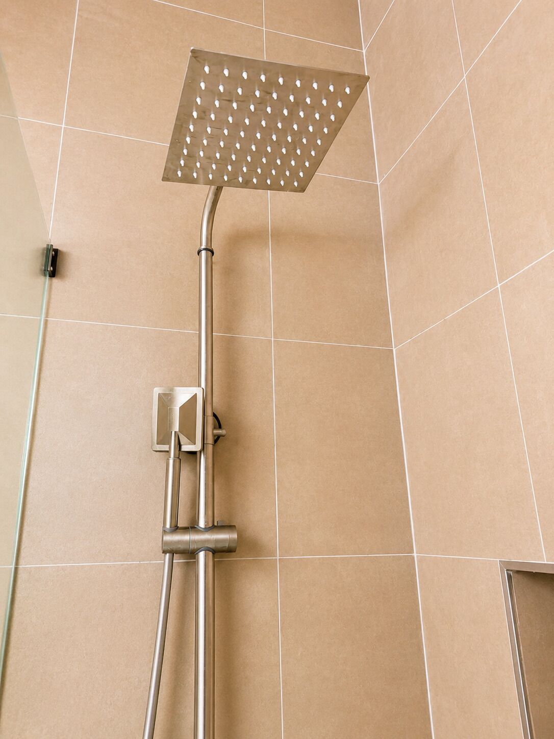 A shower with a square head and a handheld control.