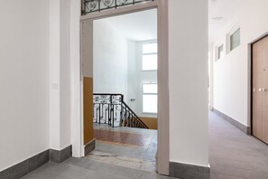 Ein Flur, der zu einer Treppe mit Metallgeländer führt.