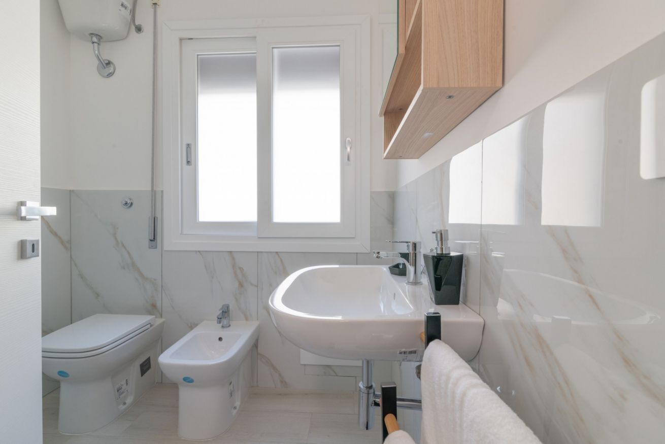 Une salle de bain moderne équipée de toilettes, d’un bidet et d’un lavabo.