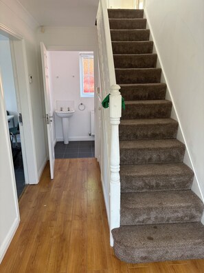 A staircase with carpeted steps leading to a landing.