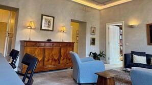 A spacious living room with a wooden cabinet, two chairs, a sofa, and a coffee table. - Chic Rome Apartment, Master + Bonus Study/Bedroom (Roma)