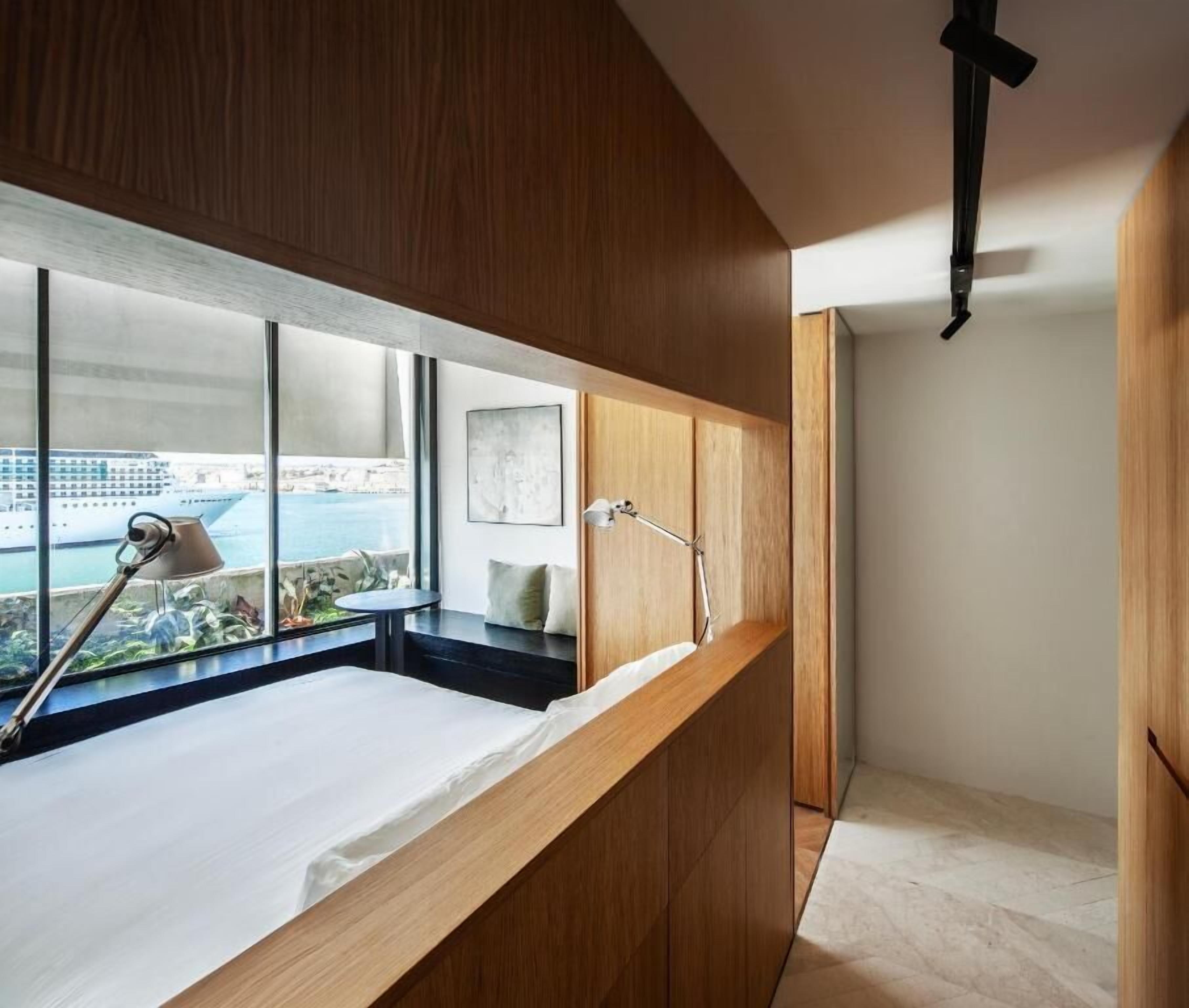 Ein modernes Badezimmer mit einem Holzkosmetikschrank, einem großen Fenster mit Blick auf die Stadt und einer Pendelleuchte.