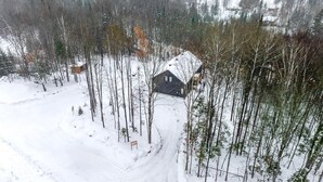 Eine Hütte, umgeben von einem verschneiten Wald.