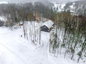 A cabin surrounded by a snowy forest. - Nayati Chalet | Luxury Chalet with Spa Near Mont-Tremblant (Amherst)