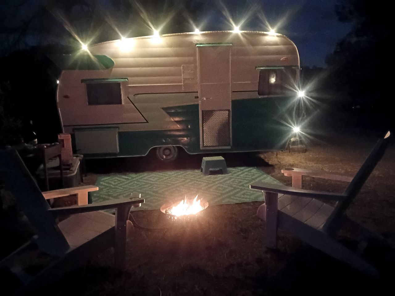 Une tente de camping équipée d’un foyer et de deux chaises.
