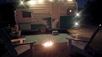 Une tente de camping équipée d’un foyer et de deux chaises.