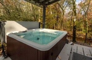 A hot tub in a wooded area with a wooden deck and a covered seating area. - Creekside Cabin Retreat with Hot Tub & Fire Pit in Caddo Gap, Arkansas (Caddo Gap)