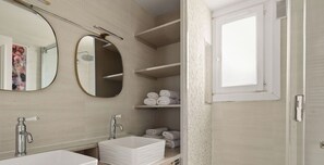 Ein modernes Badezimmer mit einem großen Spiegel, zwei Waschbecken und einem Handtuchhalter.