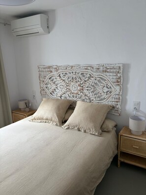 A bedroom with a bed, two bedside tables, an air conditioning unit, and a decorative wall piece. - Perfect 5-bedroom house with AC in lovely Xàbia (Xàbia)