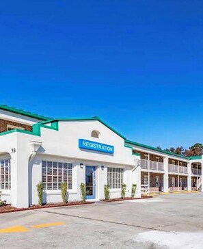 A building with a registration sign, a flat facade, and a clear blue sky.