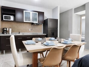 Una cocina moderna con armarios oscuros, un microondas y un refrigerador.