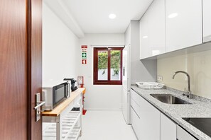 Une cuisine moderne avec des armoires blanches, un comptoir en granit et des appareils électroménagers en acier inoxydable.